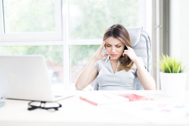 Güzel iş kadını gözleriyle ışık geniş ofis masasında oturan baş ağrısı muzdarip portresi kapalı ve onun tapınaklar sürtünme, uzay kopyalayın