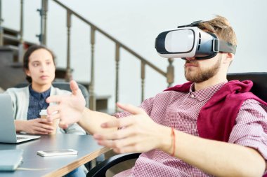 Office sandalyede oturan ve başa takılan görüntü, kadın meslektaşım gözü üstünde bulunan sanal gerçeklik keşfetmek adam genç beyaz sakallı