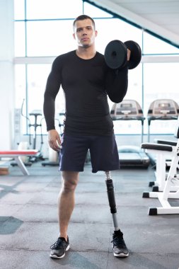 Genç atlet spor salonunda dumbbell ile eğitim portresi