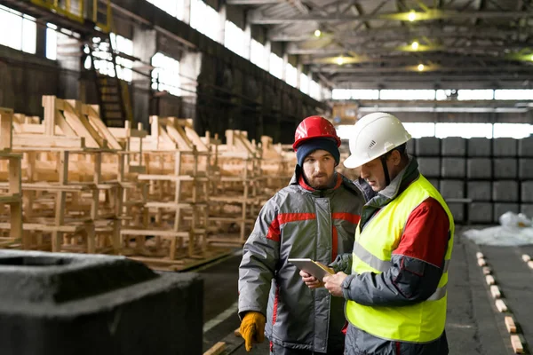 在现代工厂工作时使用数字平板电脑的两个工厂工人的腰部纵向 复制空间 — 图库照片