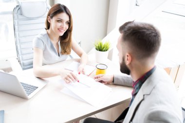 Modern kadın patron mutlu bir şekilde sözleşme istemciye sunan büyük ofise gülümseyen içinde masada oturan portresi yüksek açı