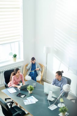 Doğrudan rapor tartışmak ve online eğe üstünde bilgisayar modern Yöneticisi istemciye köşesindeki telefonda konuşurken süre ile ilgilenen düşünceli iddialı iş arkadaşları görünümünü yukarıda.