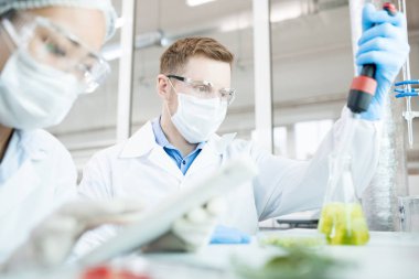 Bilim adamları koruyucu ekipman yeşil sebze test nesnesinin beslenme özellikleri eğitim araştırma yapma laboratuvar masasında oturan görünümünü kırpma