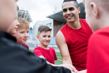 Genç futbol portresi açık stadyum maç önce motivasyon konuşması sırasında yığın eller takım, yakışıklı koç, kopya alanı üzerinde odaklanmak