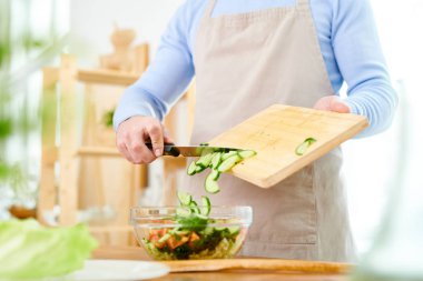 Tanınmayan adam arka plan bulanık ahşap mutfak masasında duran ailesi için sağlıklı yemek hazırlama yakın çekim çekim