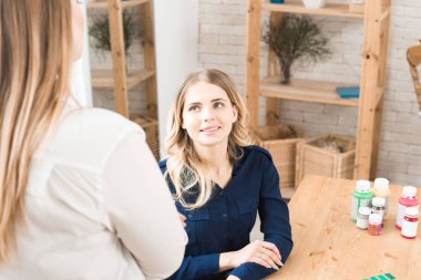 Atölyesinde genç tasarımcı oturma ve onun meslektaşı ile iletişim