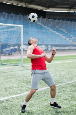 Topu kafasıyla kopya alanı isabet futbol stadyumu, yakışıklı genç adam tam uzunlukta portresi