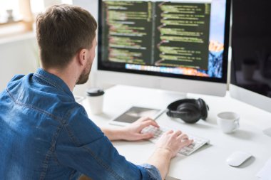 Masa başında oturan programı için kod yazma çağdaş web geliştirici portresi görünümü geri ve modern Office başlangıç proje üzerinde uzay kopyalayın