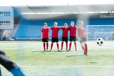 Çocuklar genç futbol takımı ayakta satırda uygulamaları sırasında Kaptan lider top ön planda, kopya alanı ile tam uzunlukta portresi