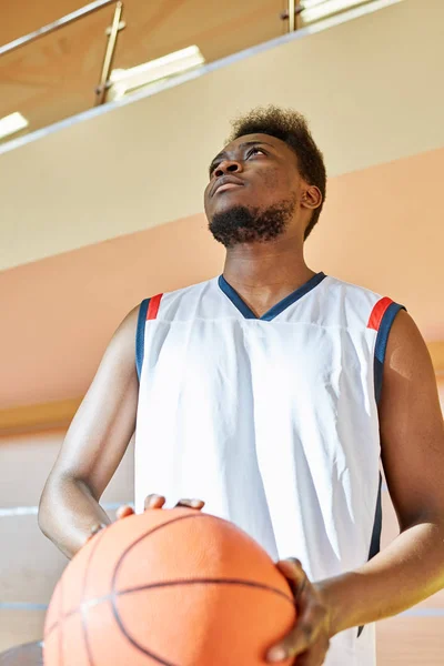 Atractivo Hombre Negro Uniforme Baloncesto Sosteniendo Pelota Mirando Hacia Arriba — Foto de Stock