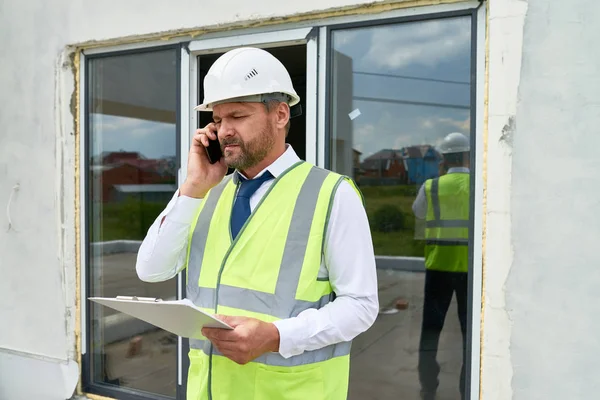 Midja Upp Porträtt Mogen Affärsman Tala Telefon Byggarbetsplatsen Bär Hardhat — Stockfoto