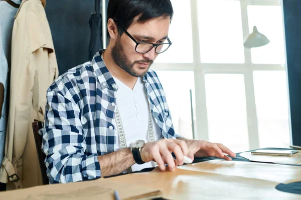 Hombre Casual Barbudo Anteojos Creando Ropa Con Patrones Costura Sentado — Foto de Stock