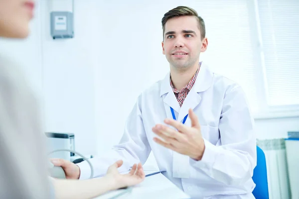 Portret Van Jonge Dokter Gesprek Met Patiënt Tijdens Vergadering Balie — Stockfoto