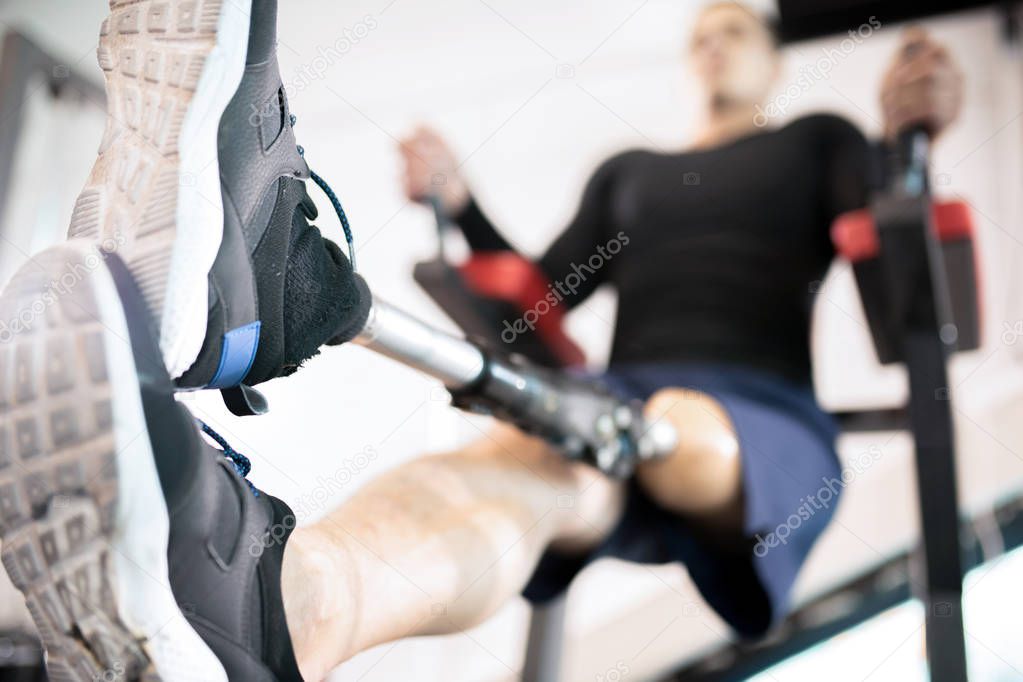 Close-up of man with an amputated leg training in gym