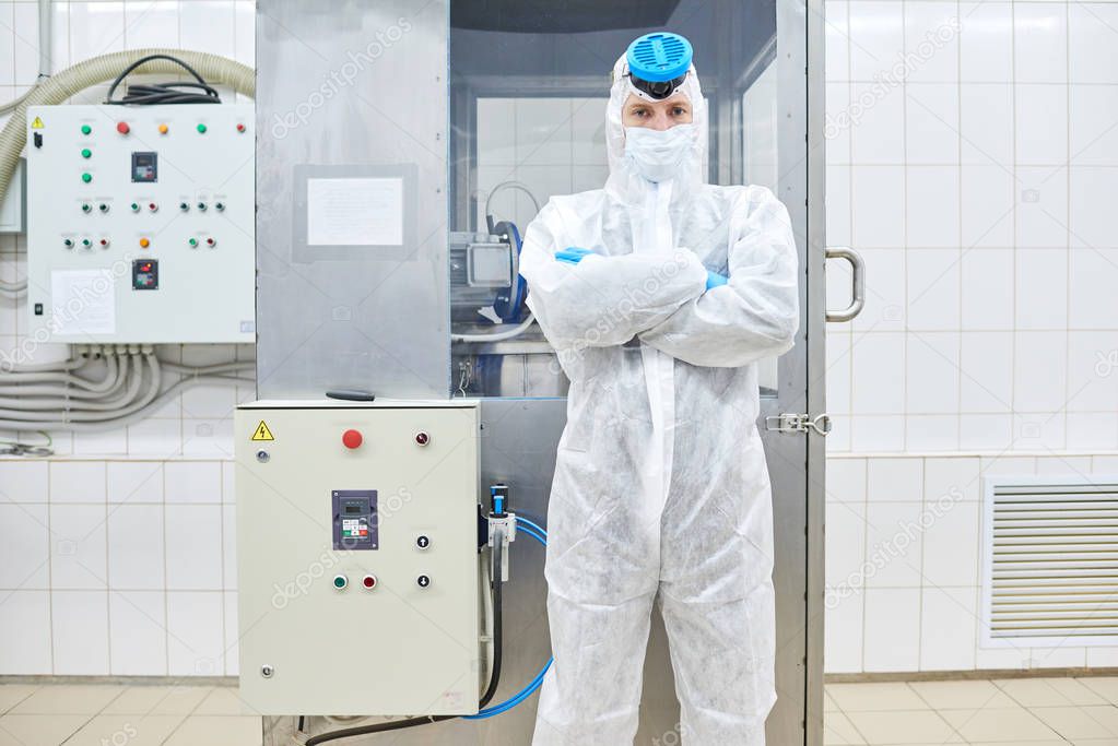 Sports nutrition production employee standing in protective clothing with arms crossed and looking at camera. 