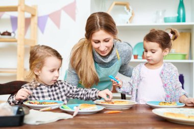 Sınıf tam hızda pişirme: renkli sır ile ev yapımı gözleme süslemek küçük kızlar açıklayan yetenekli genç pasta şefi