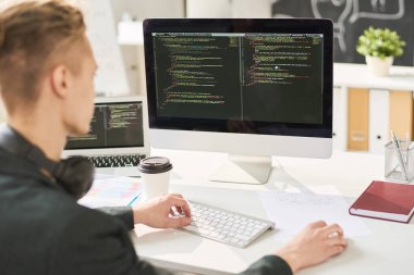 Bilgisayar programlama kodu ve modern ofis masada oturan düzenleme meşgul akıllı web geliştirici