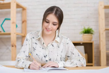 Bel öğe, dikey, ofis masası oturma ve iş ortakları ile önemli görüşmeler için hazırlanırken gerekli notlar almak oldukça genç girişimci