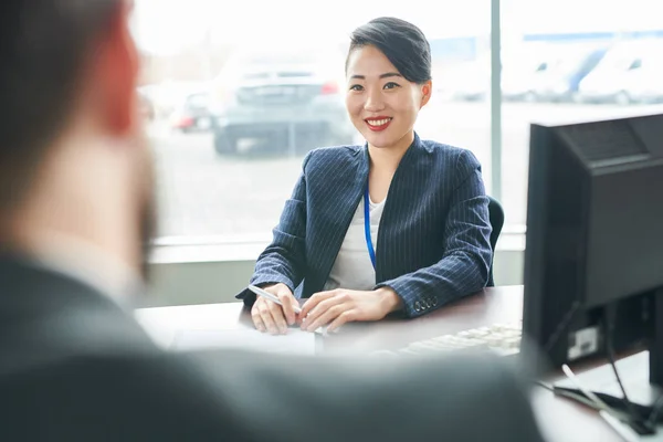 与客户一起坐在桌子上的亚洲微笑的女实业家 — 图库照片