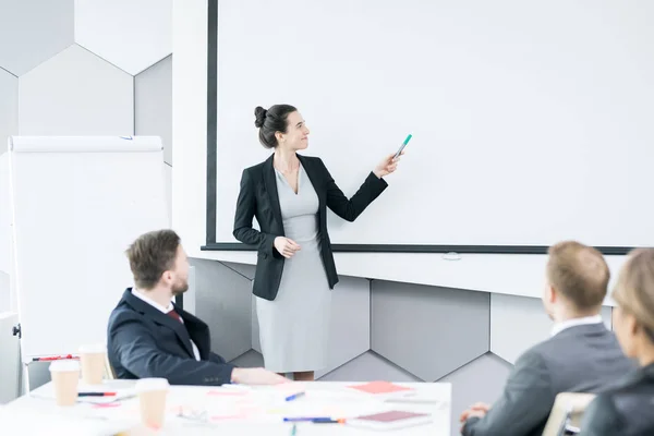 Portrait Young Businesswoman Giving Speech Front Colleagues Pointing White Projector — Stock Photo, Image