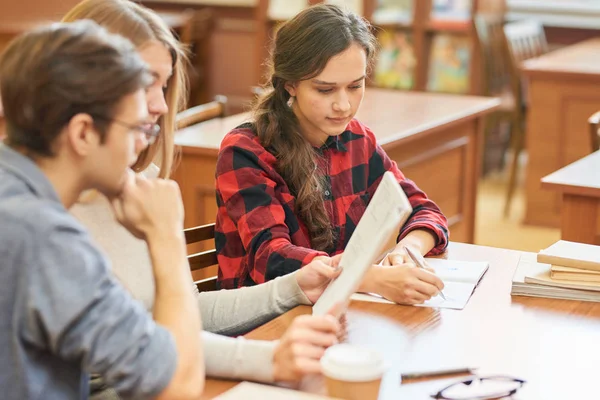 Allvarlig Eftertänksam Student Tjej Med Vågigt Hår Att Göra Anteckningar — Stockfoto