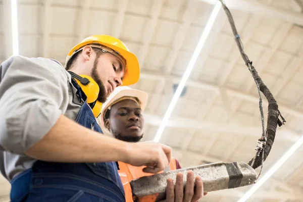 Low Angle View Concentrated Workers Wearing Uniform Protective Helmets Operating — Stock Photo, Image