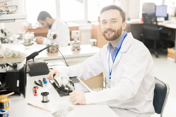 Fröhlich Selbstbewusster Bärtiger Reparaturtechniker Laborkittel Sitzt Mit Werkzeug Und Verstelltem — Stockfoto