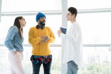 Neşeli yaratıcı genç ekip başlangıç projesini tartışıyor ve lobisinde konuşurken fikirlerini paylaşıyor