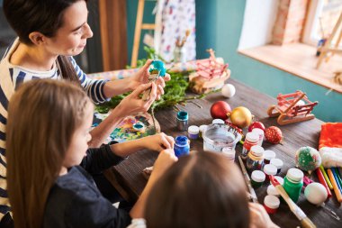 Kadın öğretmen ile işçiliği sınıfında Noel süslemeleri yapan iki küçük kız yüksek açı portre, kopya alanı