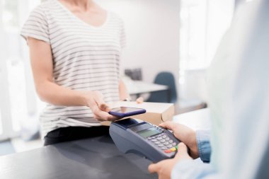 Mağaza veya kafede siparişi için Nfc üzerinden akıllı telefon ile ödeme modern tanınmaz kadın Orta bölüm portre