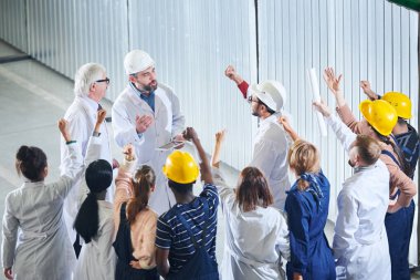 Olgun fabrika yöneticilerinin endüstriyel atölyede toplantı sırasında duygusal işçilerin grup konuşan yüksek açı portre