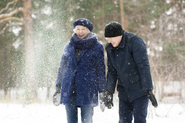 腰起兴奋的高级夫妇玩雪在冬季森林和笑快乐 复制空间 — 图库照片