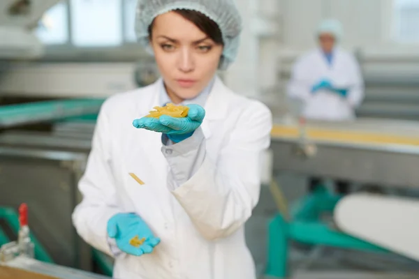 現代の食品工場で働き 生産ラインでマカロニを検査する若い女性の肖像画 前景に焦点を当て スペースをコピー — ストック写真