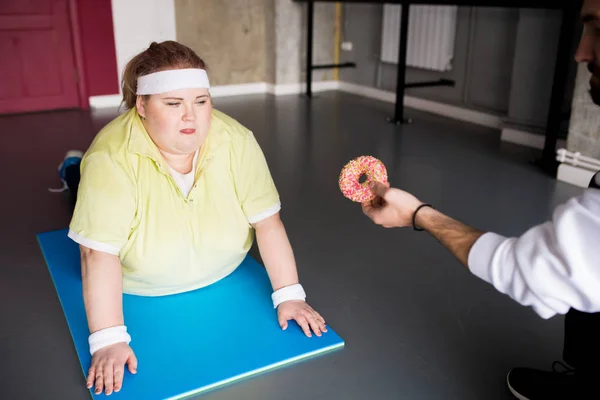 Ritratto Giovane Donna Obesa Che Allena Sdraiata Tappeto Guarda Ciambella — Foto Stock