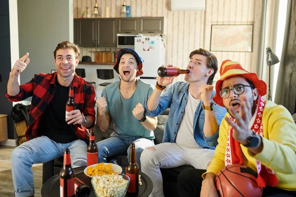 一群年轻人在电视上一起看足球比赛 在家里喝啤酒和薯条 — 图库照片
