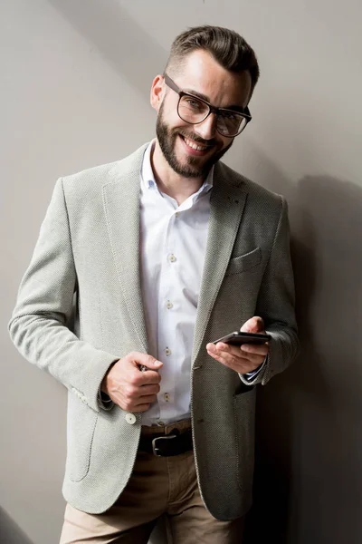 Retrato Elegante Jovem Gerente Segurando Smartphone Sorrindo Isolado Fundo Cinza — Fotografia de Stock