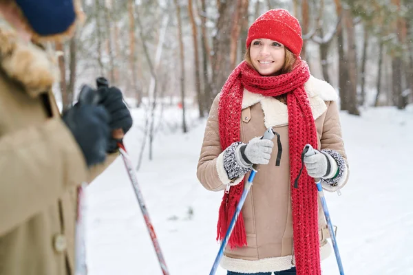 腰起美丽的年轻女子微笑和看着男朋友 同时享受滑雪在美丽的冬季森林 复制空间 — 图库照片