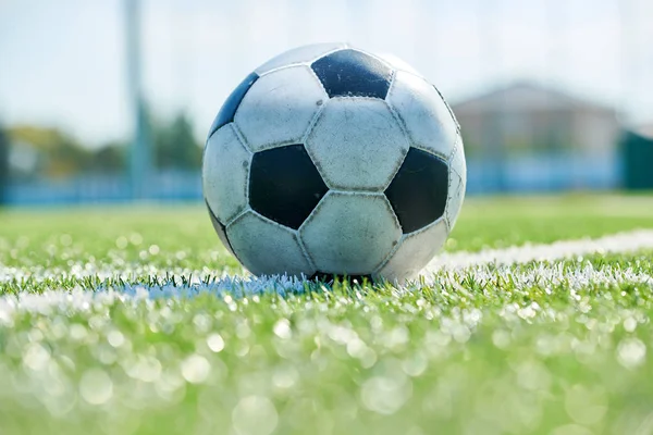 Açık alanda çim üzerinde yatan futbol topu aşırı yakın, kopya alanı