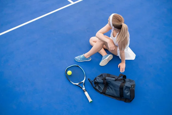 연습에서 휴식을 취하는 테니스 코트에서 바닥에 여자의 초상화 — 스톡 사진