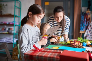 Sanat ve zanaat sınıfında el yapımı Noel hediyeleri yapma sevimli Asya kız Yan görünüm portre, uzay kopyalamak