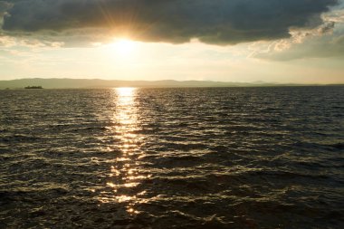 Bulutlu gökyüzü ile gölde güzel gün batımı