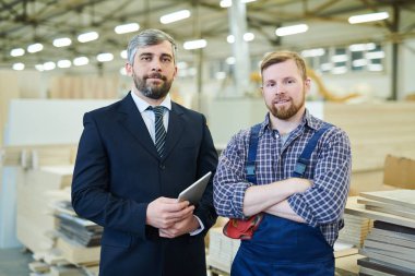 İçerik emin yakışıklı sakallı işadamı takım elbise li tablet tutan ve üniformalı gülümseyen genç mühendis yanında duran, onlar kamera bakıyor, yatırımcı sanayi tesisi ziyaret