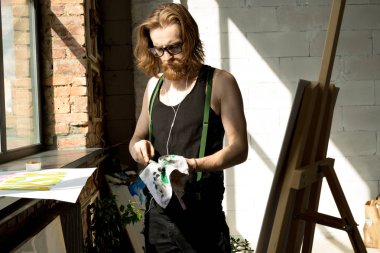 Sanat stüdyosunda şelat la resim yaparken çağdaş uzun saçlı sanatçının portresi kadar bel, kopya alanı