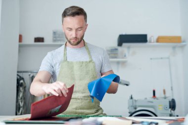 Konsantre master yeni ürün için deri kumaş uygun parçaları seçerek