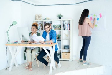 Küçük beyaz ofiste çalışan üç modern tasarımcıların tam uzunlukta portre, kopya alanı