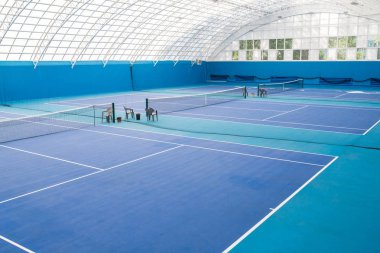 Mavi renklerde modern kapalı tenis kortu iç geniş açı görünümü, kopya alanı
