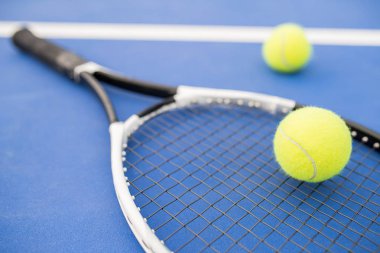 Sarı tenis topu ve raket sahada mavi katta döşeme spor arka plan, kopya alanı