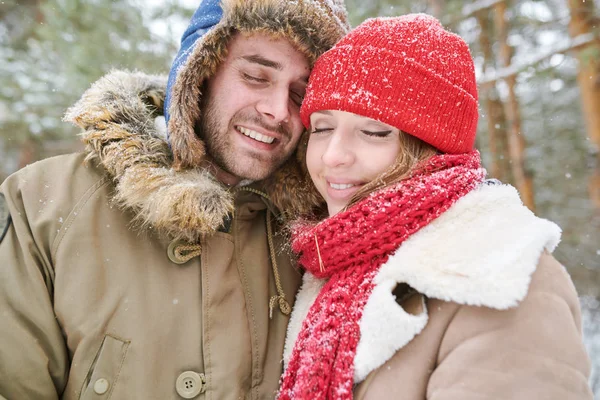 头和肩膀的肖像 可爱的年轻夫妇温柔拥抱和微笑 闭上眼睛 同时享受在雪雪的冬季森林散步的日期 — 图库照片