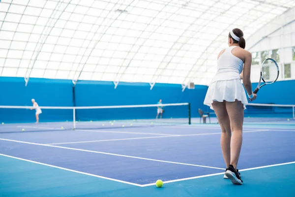 全長バックビュー屋内コートでのトレーニング中にラケットを保持している女性のテニスプレーヤーの肖像画 コピースペース — ストック写真