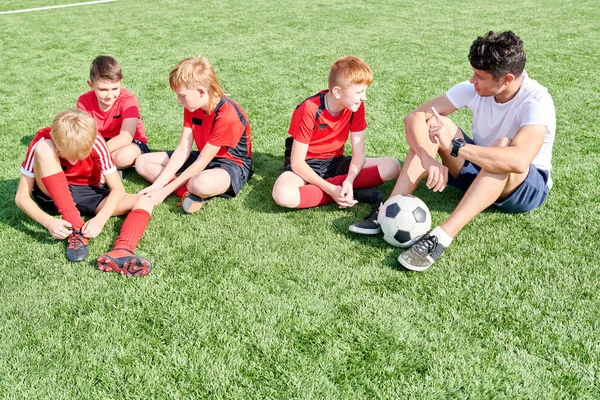 Ganztägiges Porträt Der Juniorenfußballmannschaft Auf Dem Rasen Sitzend Und Dem — Stockfoto